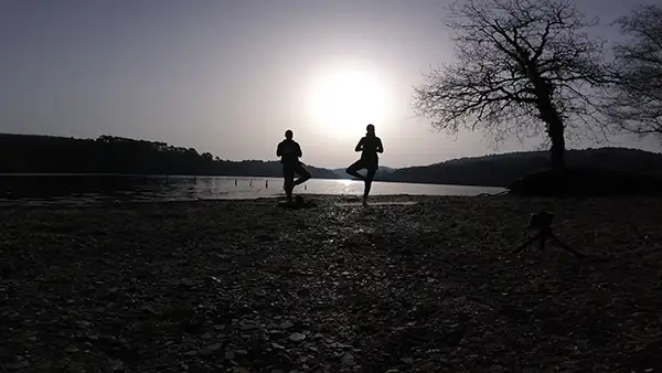 Cours individuel de yoga en extérieur dans le Pays de Pontivy, donné par Charlie Markwitz pour Atman Yoga, sur les berges du lac de Guerlédan.